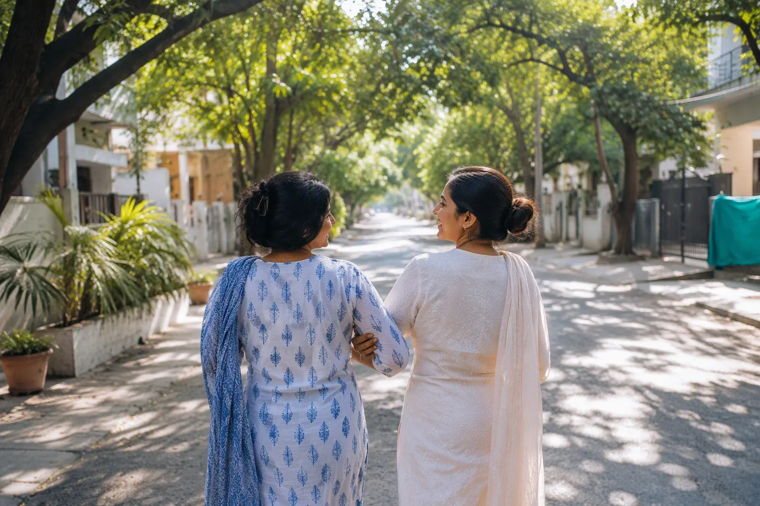 Two friends walking arm in arm down a leafy lane on a sunny afternoon